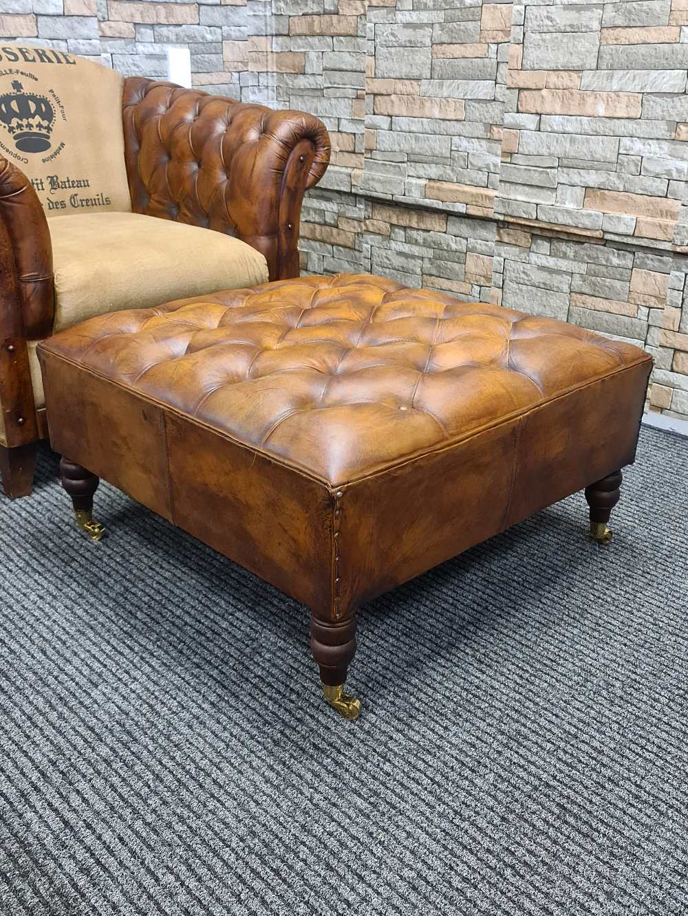 LINCOLN LEATHER OTTOMAN WITH BRASS WHEELS